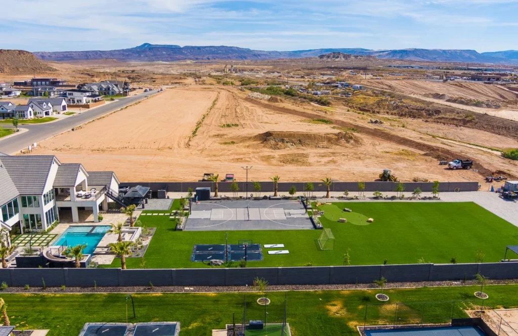 An expansive desert landscape featuring vibrant green artificial turf contrasting with the surrounding arid environment